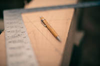 framing square and pencil laying on a timber