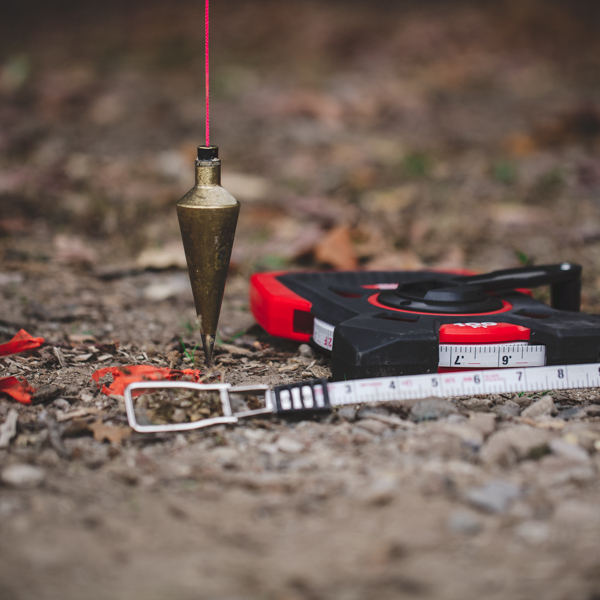 plumb bob hanging on a string with a tap meausure