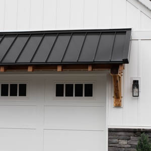 eyebrow roof with metal roof over garage door